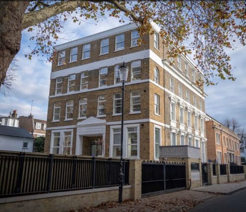 stately multi-story brick building at Atlantic House, with white accents and autumn leaves overhead