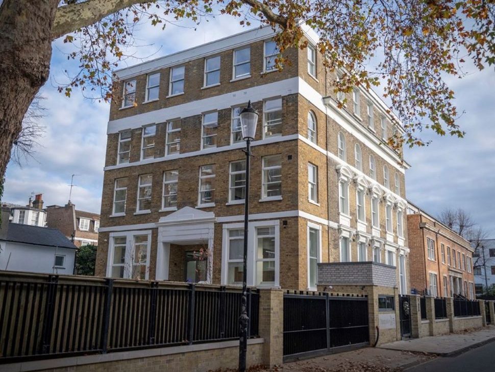 stately multi-story brick building at Atlantic House, with white accents and autumn leaves overhead
